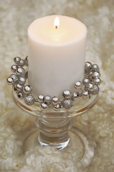 large white candle with a candlestick on a white background.