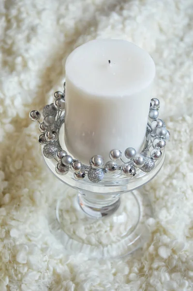 large white candle with a candlestick on a white background.