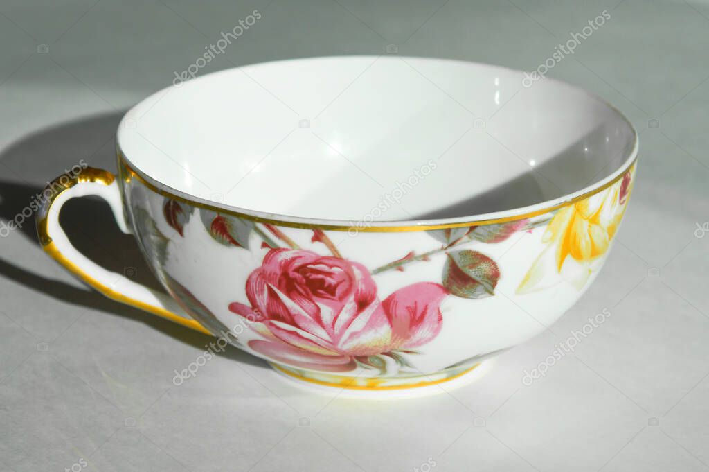 white tea mug with flowers on a white background.