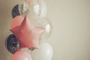 Balonlar hafif arka planda. Pembe, beyaz ve gri balonlar. Durumun dekoru..