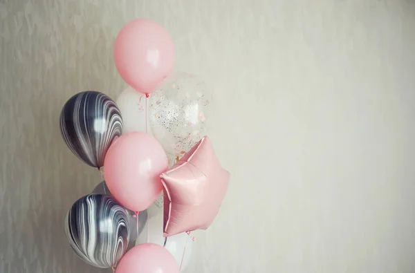 balloons on a light background. pink, white, and gray balloons. the decor of the occasion.