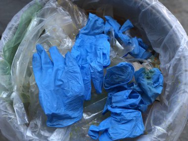 Çöp kutusundaki mavi bulaşıcı tıbbi eldiven, bulaşıcı atık, virüsün covid-19 'u ayırarak....