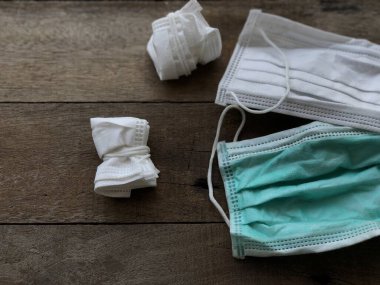 Engellenen covid-19 kavramı. Enfeksiyon maskesi ve kirli tıbbi eldiven ahşap masa üstü, bulaşıcı atık, virüsün covid-19 'u engellemesi enfekte olmuş atıkları ayırmak, seçici odaklanma.