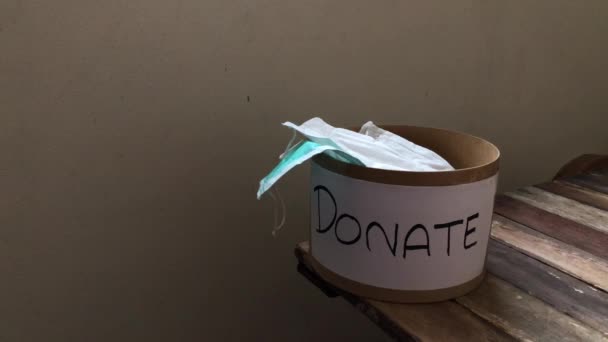 捐款箱的木桌顶部有卫生的医疗面罩 用于帮助穷人或医务人员 病灶轻微 有选择性 — 图库视频影像