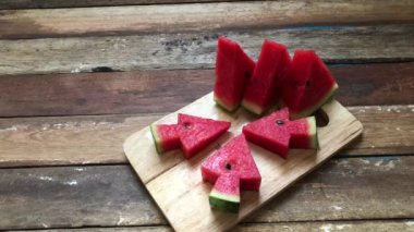 Tahtada taze karpuz, noel ağacı gibi üçgenle dilimlenmiş loş ışık, seçici odaklanma. Yaz zamanı için meyve..