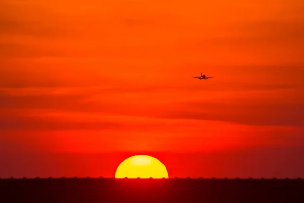 Şehrin Üzerinde Gün Batımı Uçak Silueti — Stok fotoğraf