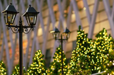 Noel bayramı festivali için arka planda bulanık Noel ağacı olan fener..