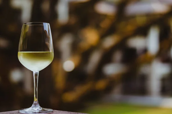 Ein Glas Weißwein Auf Dem Tisch Mit Verschwommenem Baumhintergrund — Stockfoto