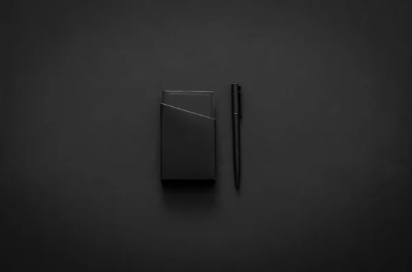 Name card box and pen in modern lifestyle on dark background for minimalist flat lay black concept