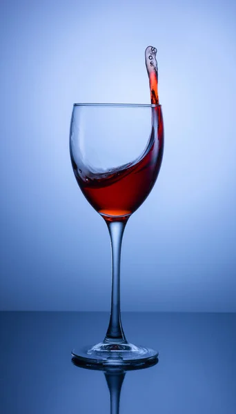 Arka planda kırmızı bir şarap bardağına sıçradı.