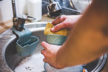 Tabaklarım bir stajyer süngerle akan suyun altında.