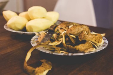 Evde bıçakla patates soyuyordu.