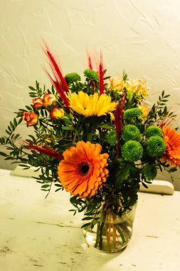 Gri arkaplandaki vazoda farklı renklerde güzel buketler.