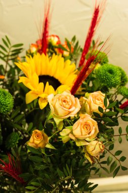 Gri arkaplandaki vazoda farklı renklerde güzel buketler.