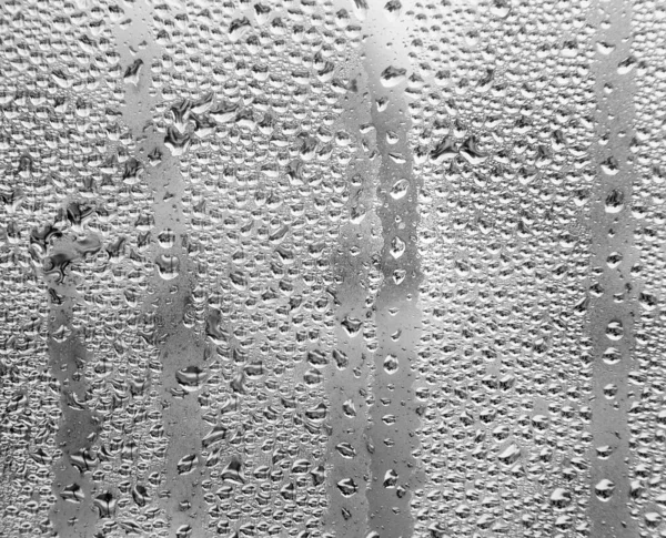 Wet window glass. Background image with drops. View from home on a rainy day.