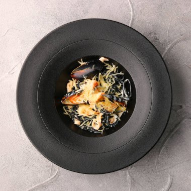 Midyeli ve peynirli siyah makarna.,