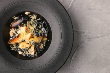 Midyeli ve peynirli siyah makarna.,