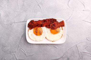 Pastırmalı sahanda yumurta. Kahvaltı konsepti. Işık arkaplanındaki üst görünüm.