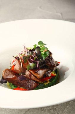 Lokanta bifteği ve mikro-yeşil yakın plan beyaz plaka içinde ışık arka plan