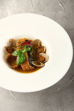 Beyaz tabakta otlu midye ve somon.