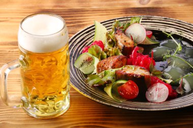 Tahta masada sebzeli zander salatası. Balık ve bira için limon.