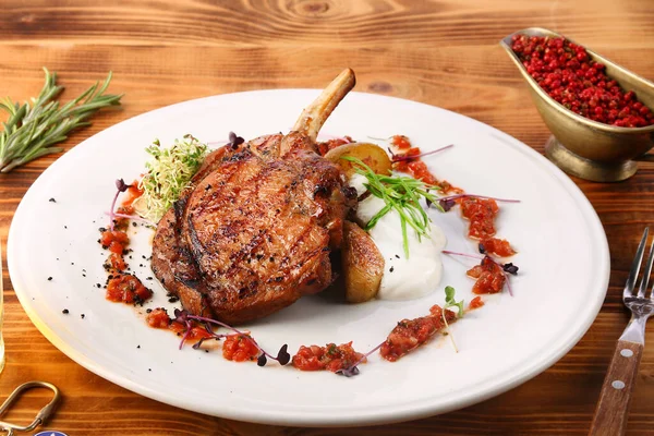 Tahta masada patates ve cam bardakta bira ile taze ızgara biftek.