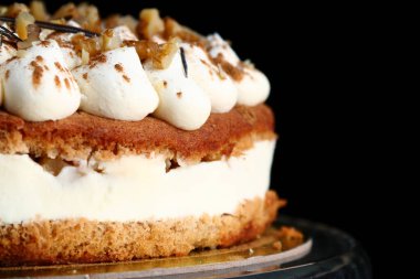 Cevizli ve krem peynirli kek yakın plan. Kadın avcıları havuç tatlısı tutar..