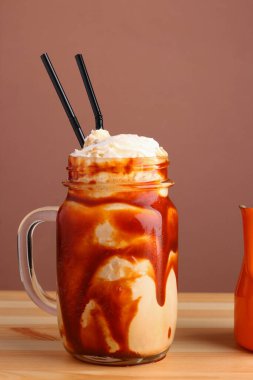 Tahta masada kahve ve karamelli milkshake. Tuzlu karamelli dondurma. Soğuk kahve frappe frappuccino, kremalı.