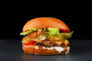 Koyu izole edilmiş arkada tavuklu lezzetli bir burger. Taze sebze ve peynirli ev yapımı hamburger veya hamburger.