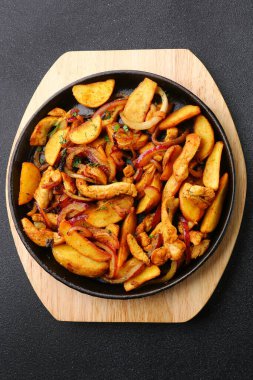 Patatesli tava ve siyah beton. Meksika yemeği konsepti. Tavada kızarmış patates.