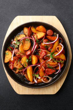 Patates etli tava ve siyah beton sırtlı soğan. Meksika yemeği konsepti. Tavada kızarmış patates.