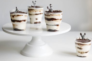 Cam ve hafif arka planda klasik tiramisu. Işık arkaplanındaki bölümlendirilmiş tiramisu