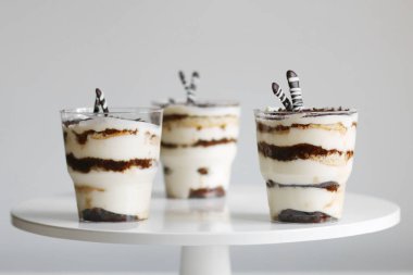 Cam ve hafif arka planda klasik tiramisu. Işık arkaplanındaki bölümlendirilmiş tiramisu