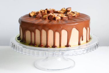 Sırtında karamel olan çikolatalı pasta. Snickers keki. Çikolatalı tatlı.