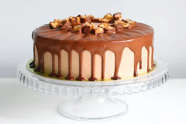 Sırtında karamel olan çikolatalı pasta. Snickers keki. Çikolatalı tatlı.