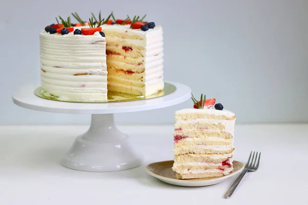 Crepe cake with strawberry blueberry and rosemary on light background. Crepes cake with cottage cheese and strawberry, selective focus