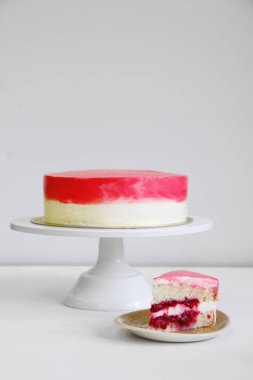 Beyaz masadaki vişne renginde pasta. Tatlı konsepti dilimlenmiş pasta