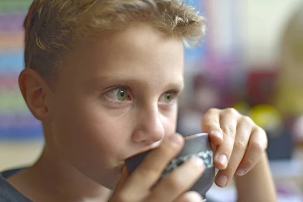 Sevimli küçük çocuk bir bardak çay içiyor