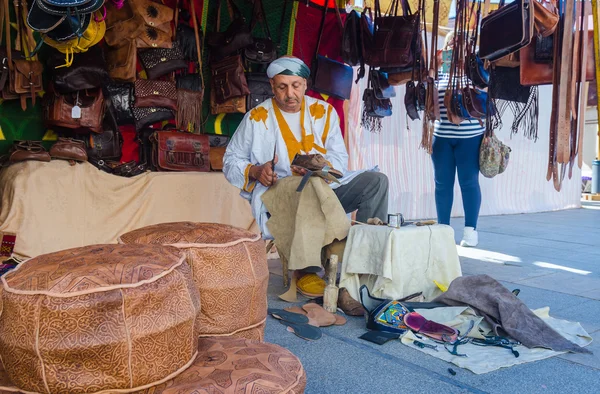 Hombre árabe haciendo zapatos en un mercado — Foto de Stock