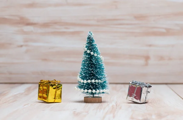 Pequeño árbol de Navidad y regalos sobre fondo de madera —  Fotos de Stock