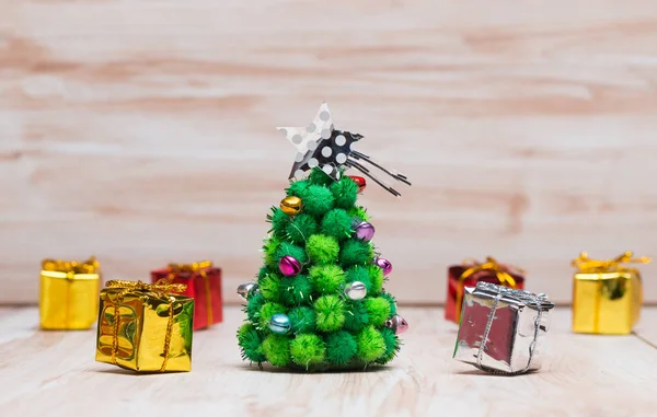 Pequeño árbol de Navidad y regalos sobre fondo de madera —  Fotos de Stock