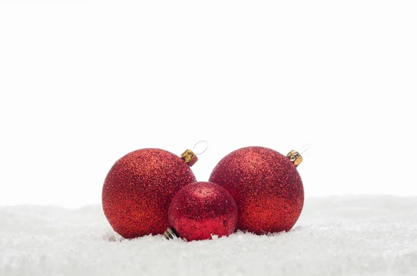 Boules de Noël rouges couchées sur la neige — Photo