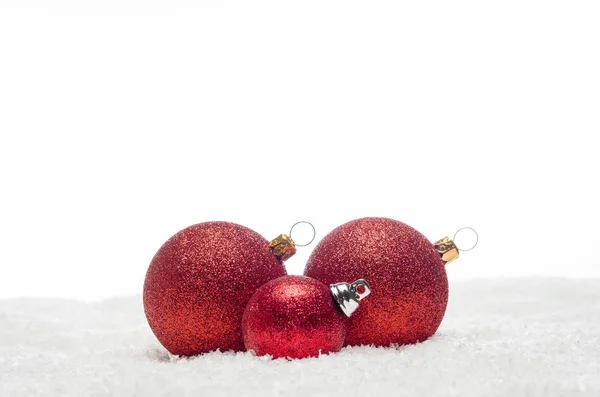 Червоні різдвяні кульки лежать на снігу — стокове фото
