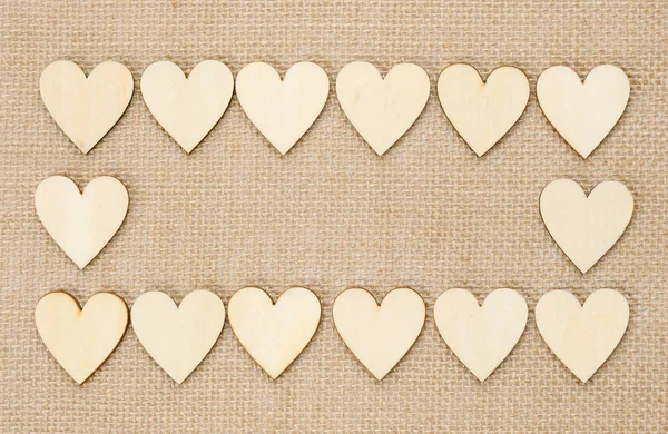 Wood hearts on hessian texture background, valentine background — Stock Photo, Image