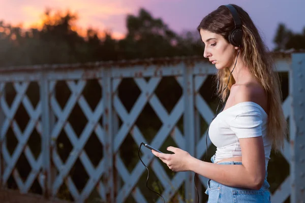 Bela jovem mulher olhando para fote inteligente — Fotografia de Stock