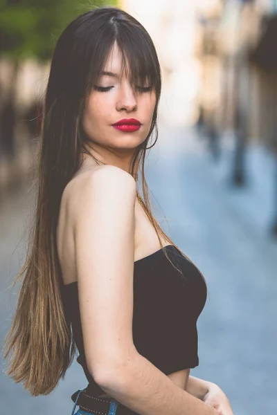 Menina bonita com os olhos fechados posando na rua — Fotografia de Stock