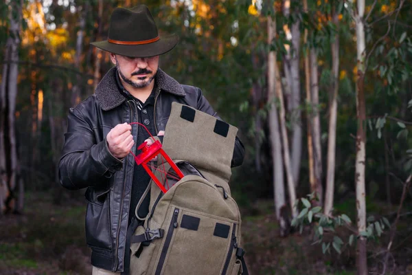 Homme avec chapeau et veste attrapant vieille lampe de sac à dos — Photo