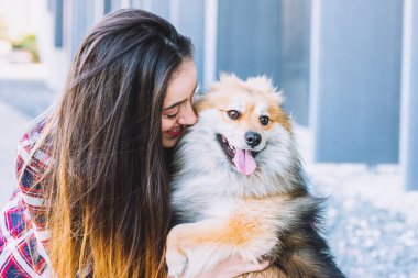 Sokakta güzel köpeğe sarılan güzel bir kadın.