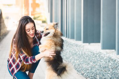 Mutlu kadın, metin için fotokopi alanı olan sevimli köpeği tutuyor.