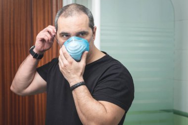 Virüs konseptinin yayılmasını önlemek için koruyucu maske takan bir adamın portre fotoğrafı.